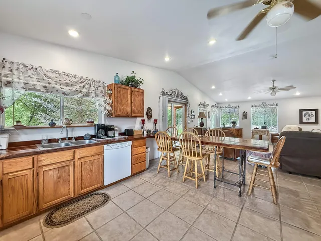 a dining hall with stainless steel appliances granite countertop a table and chairs