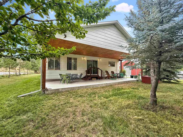 a view of a patio with table and chairs under an umbrella