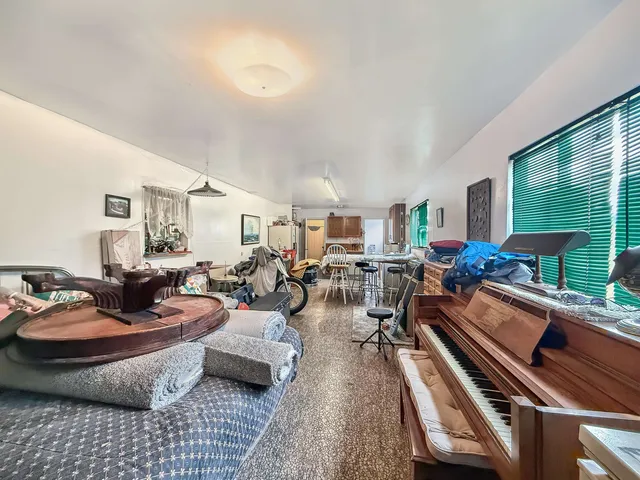 a living room with furniture a rug and a floor to ceiling window