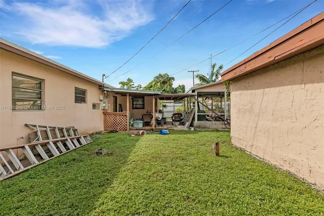 a view of a backyard with table and chairs and a barbeque
