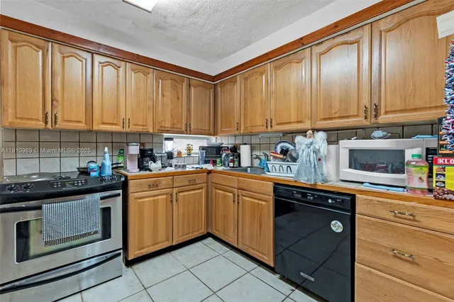 a kitchen with stainless steel appliances granite countertop a sink a stove and cabinets