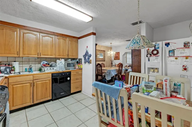 a kitchen with stainless steel appliances kitchen island granite countertop a refrigerator and microwave