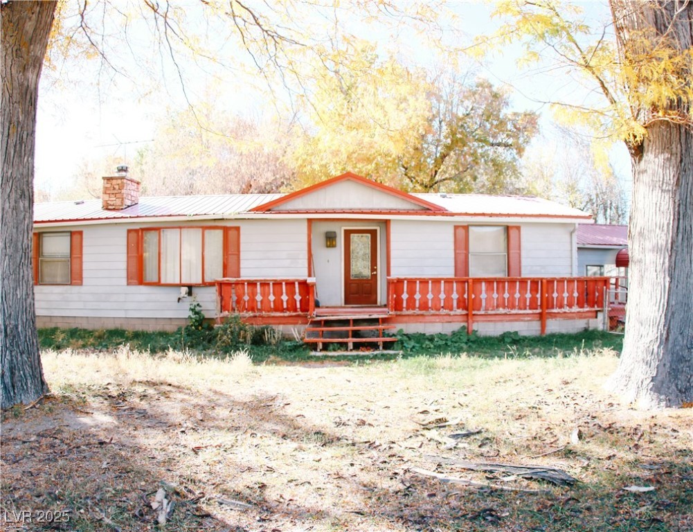Ranch-style home with a metal roof and a chimney