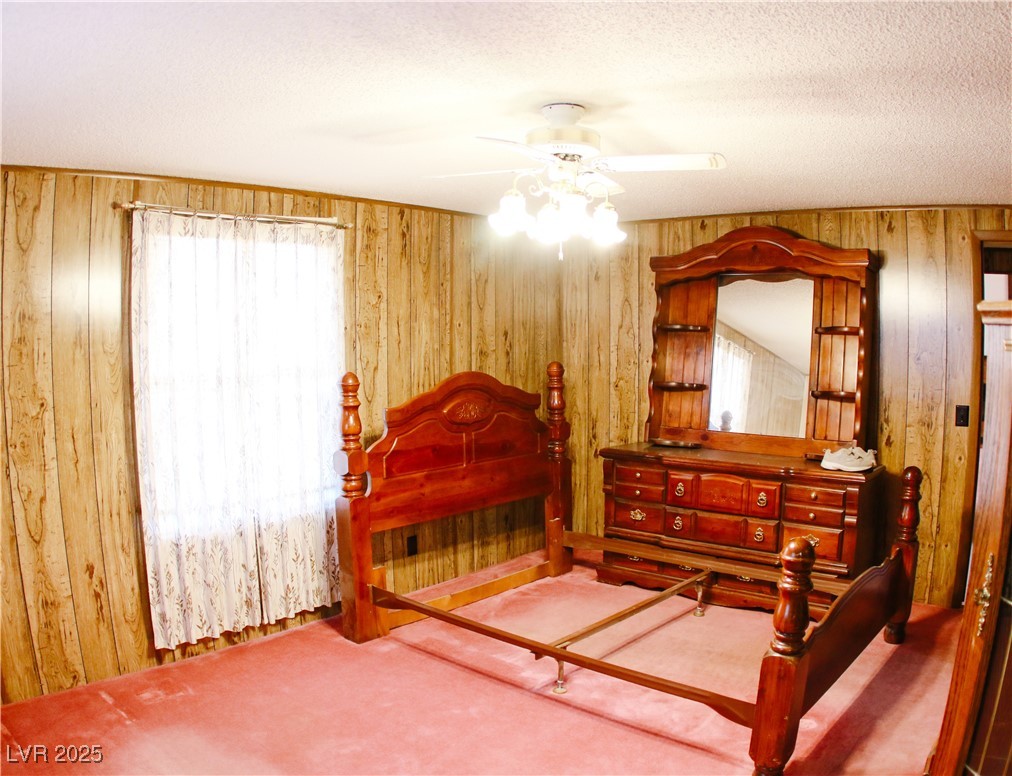 31 South 4th Street Panaca, NV 89042 - Photo 15 of 36 Bedroom featuring carpet floors, wood walls, and ceiling fan