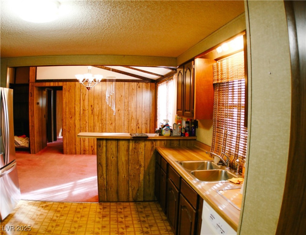 31 South 4th Street Panaca, NV 89042 - Photo 18 of 36 Kitchen featuring light floors, a textured ceiling, freestanding refrigerator, light countertops, and white dishwasher