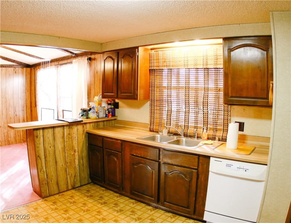 31 South 4th Street Panaca, NV 89042 - Photo 19 of 36 Kitchen featuring white dishwasher, a peninsula, light countertops, a textured ceiling, and light flooring