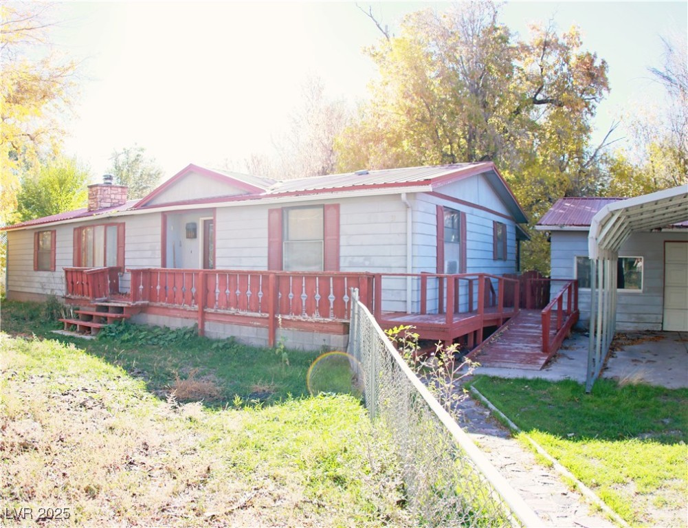 31 South 4th Street Panaca, NV 89042 - Photo 3 of 36 View of front facade featuring a metal roof, a deck, a chimney, and a front yard