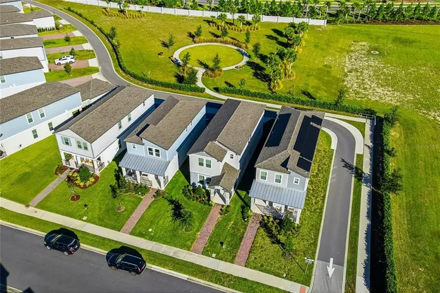 an aerial view of a residential houses with outdoor space and parking