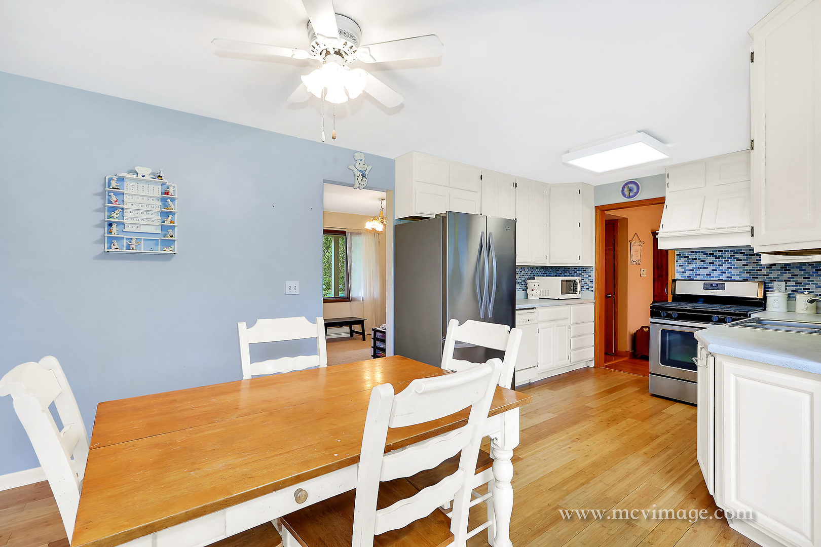 359 High Road Cary, IL 60013 - Photo 11 of 32 a kitchen with stainless steel appliances kitchen island granite countertop a refrigerator a stove a microwave oven with white cabinets and wooden floor
