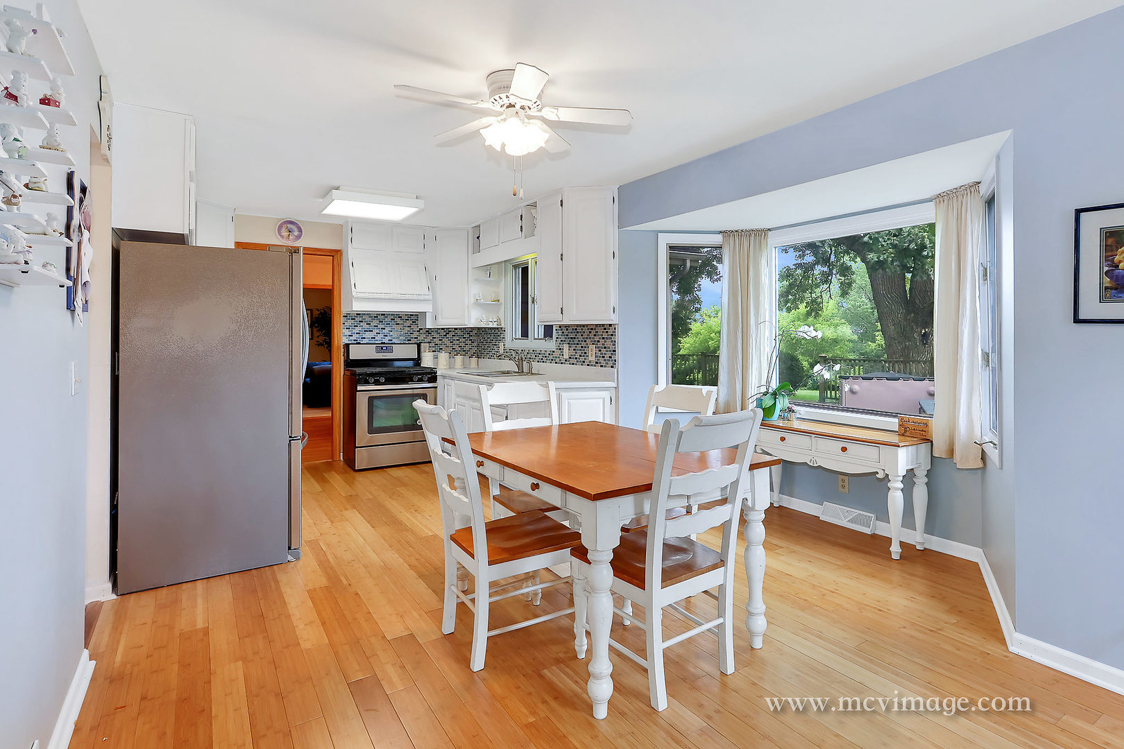 359 High Road Cary, IL 60013 - Photo 10 of 32 a kitchen with stainless steel appliances kitchen island granite countertop a refrigerator a stove a dining table and chairs with wooden floor