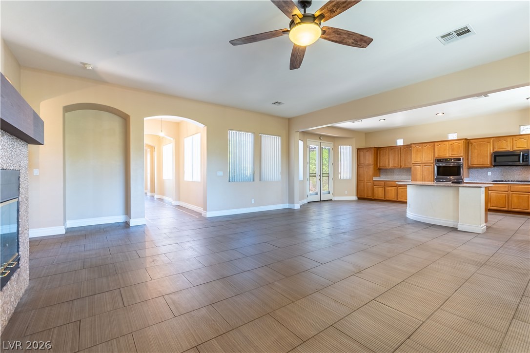 3334 Garden Shower Place Las Vegas, NV 89135 - Photo 31 of 32 An open floorplan seamlessly connects the expansive living area and kitchen over durable tile flooring.