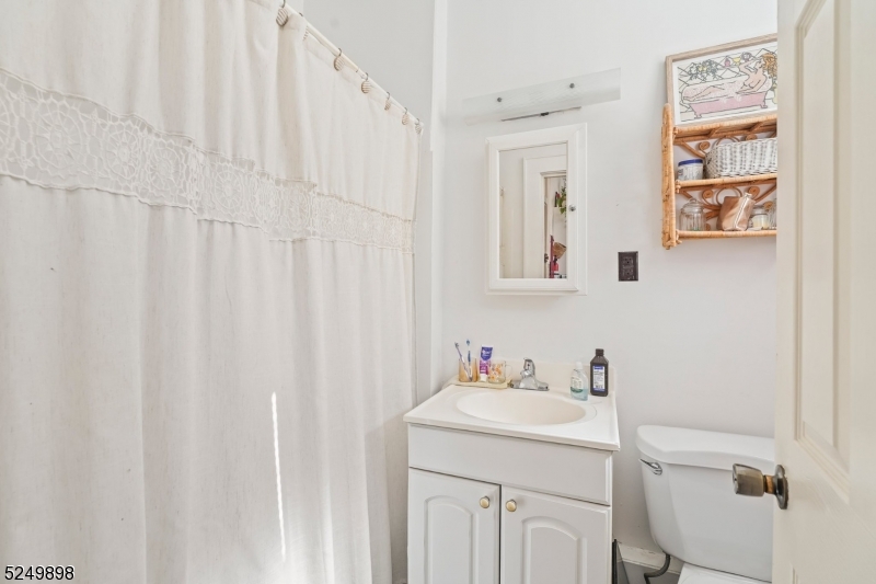 460 Bloomfield Avenue, Unit 3 Caldwell, NJ 07006 - Photo 7 of 8 a bathroom with a sink a toilet and a mirror