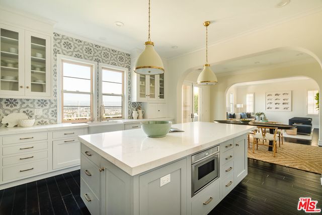 a kitchen with a sink a stove and white cabinets