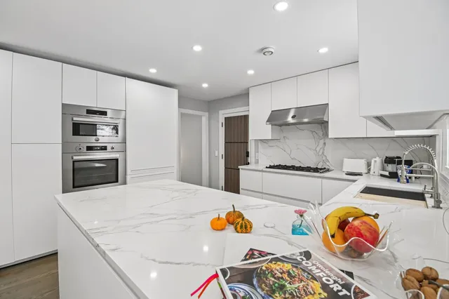 a kitchen with stainless steel appliances granite countertop a refrigerator and a stove