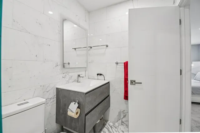 a bedroom with a large bed a flat tv screen and a dresser