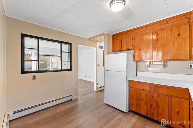 a kitchen with a refrigerator a stove top oven and a window