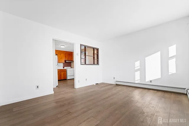 a view of a room with wooden floor and window