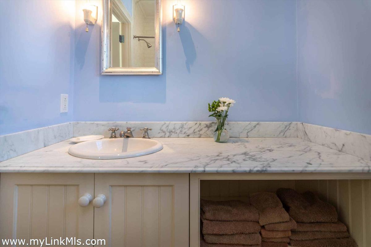 25 Lelands Path Edgartown, MA 02539 - Photo 51 of 56 a bathroom with a granite countertop sink and a mirror