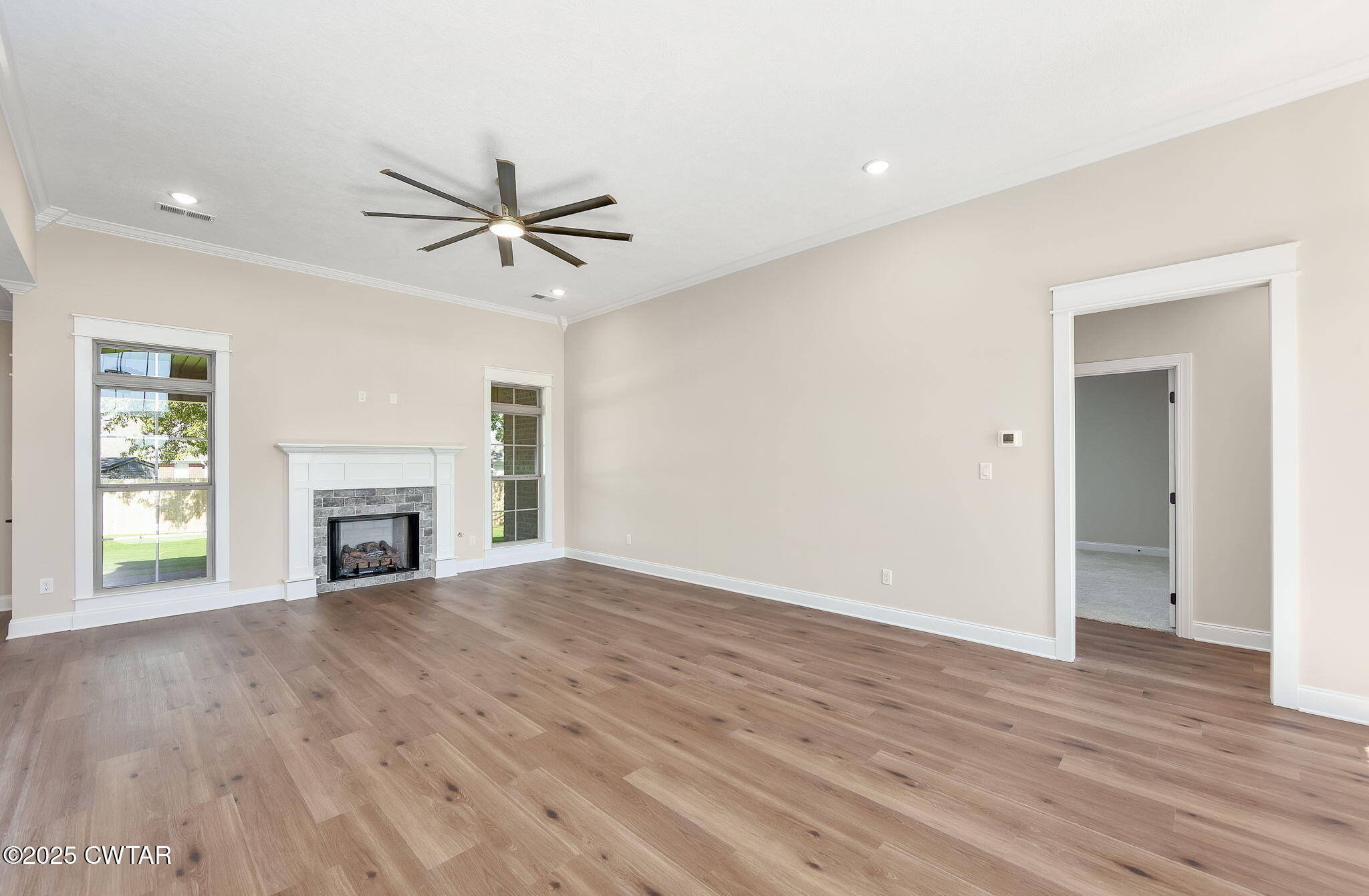 24 Enoch Cove Jackson, TN 38305 - Photo 5 of 30 an empty room with fireplace chandelier fan and windows