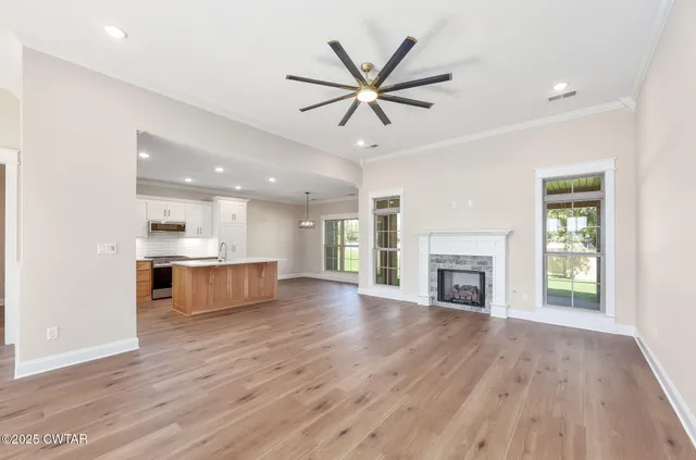 a view of a big room with wooden floor and a kitchen