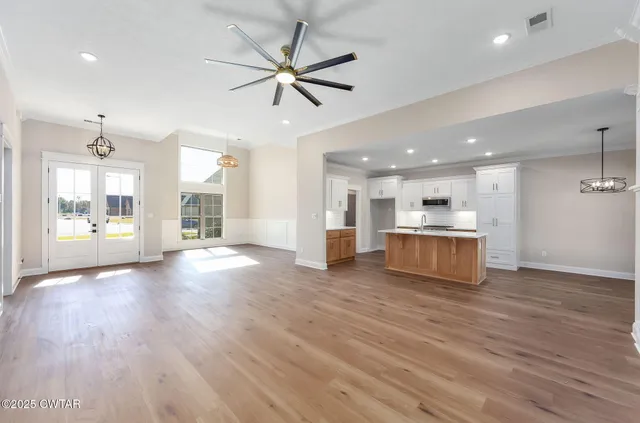 a kitchen with a sink window and wooden floor