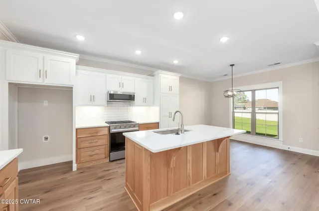 a kitchen with a stove a sink and a refrigerator