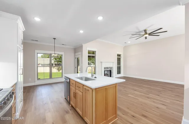 a kitchen with a sink stove and wooden floor