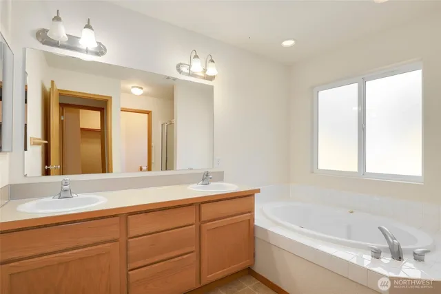 a bathroom with double vanity sinks and a bathtub