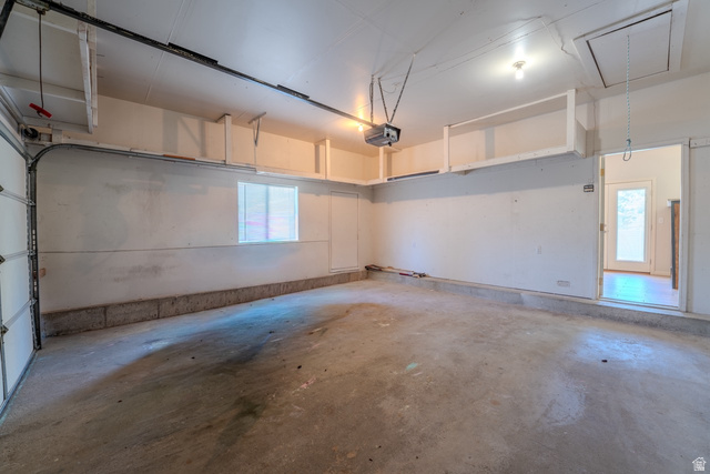 11957 Noelle Road Sandy, UT 84092 - Photo 30 of 38 Spacious garage featuring a concrete floor, overhead storage shelving, and an interior access door