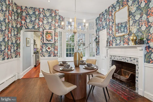 a dining room with furniture a fireplace and wooden floor