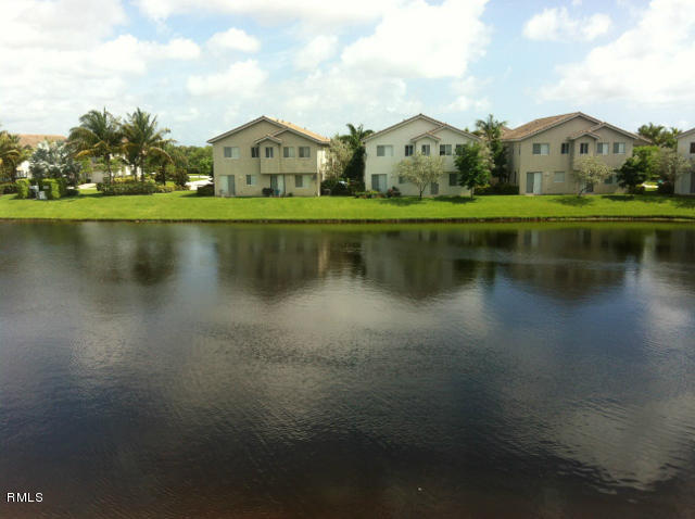 3182 Laurel Ridge Circle Riviera Beach, FL 33404 - Photo 16 of 23 a front view of a house with a yard and lake view
