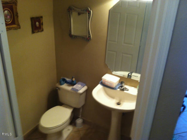 3182 Laurel Ridge Circle Riviera Beach, FL 33404 - Photo 8 of 23 a bathroom with a toilet sink and mirror