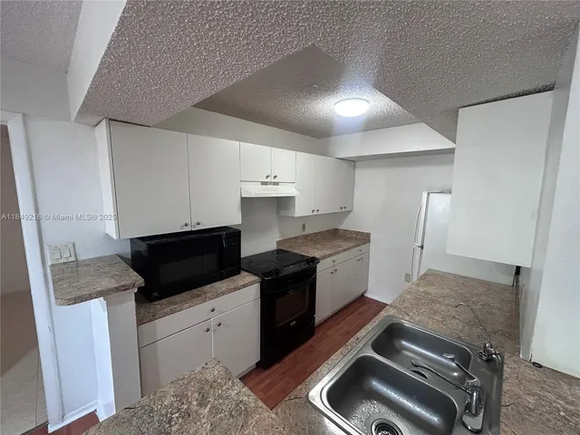 a kitchen with a sink stove and cabinets