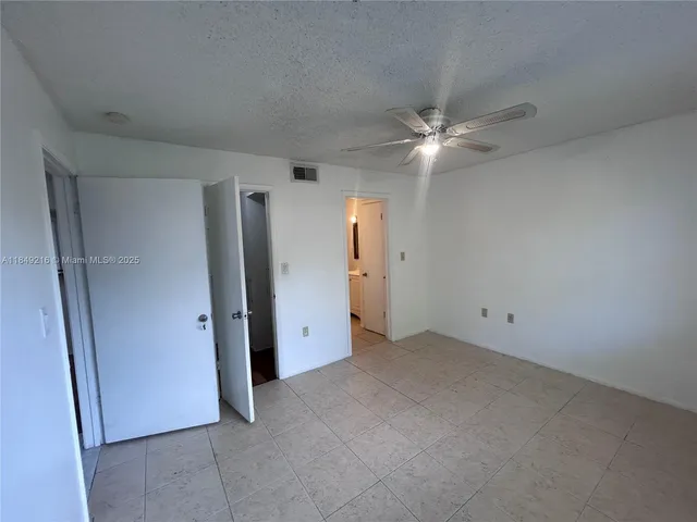 an empty room with closet and a ceiling fan