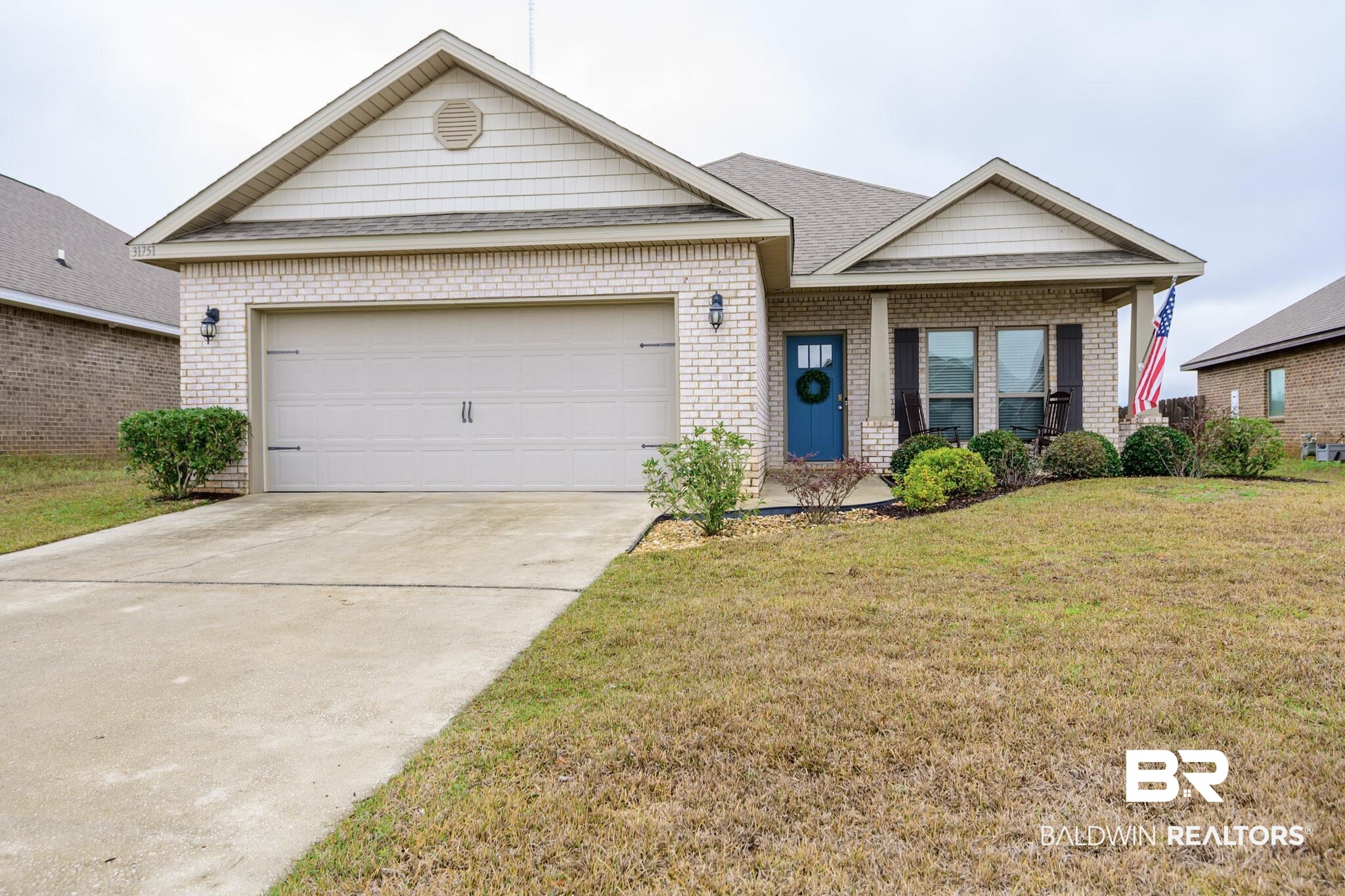 31751 Kestrel Loop Daphne, AL 36527 - Photo 1 of 21 Ranch-style home with an attached garage, covered porch, concrete driveway, a front yard, and roof with shingles