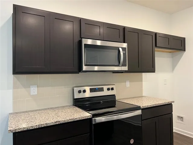 a kitchen with stainless steel appliances wooden cabinets and a microwave