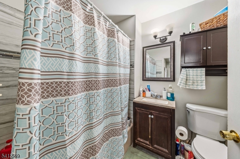 747 North Broad Street Elizabeth, NJ 07208 - Photo 7 of 13 a bathroom with a sink a toilet and mirror