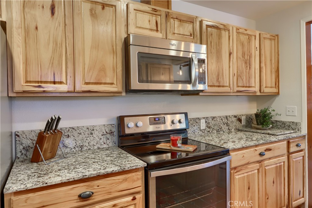5641 Darrah Road Mariposa, CA 95338 - Photo 19 of 58 a kitchen with granite countertop white cabinets and a stove top oven