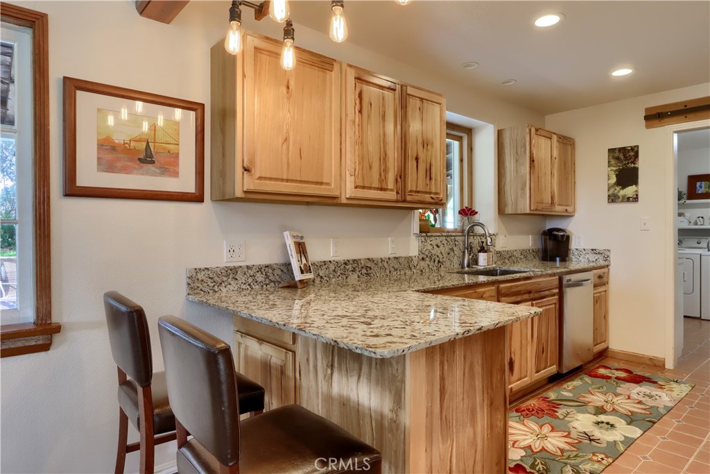 5641 Darrah Road Mariposa, CA 95338 - Photo 20 of 58 a kitchen with stainless steel appliances granite countertop a stove a sink dishwasher and cabinets with wooden floor