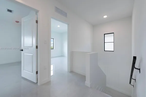 a view of a hallway with closet and mirror