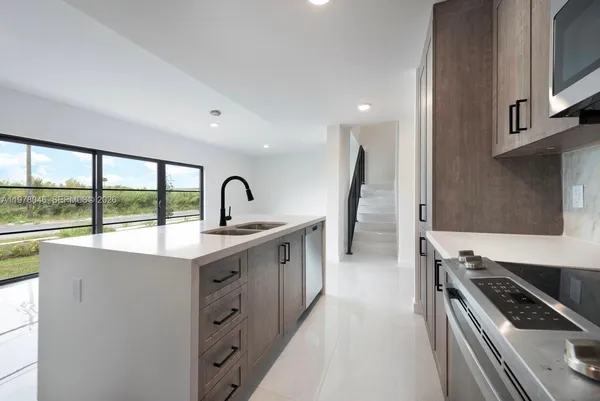 a kitchen with windows a sink and a stove