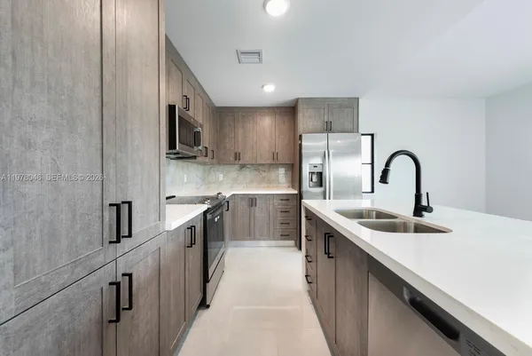 a kitchen with stainless steel appliances granite countertop a sink a stove and a refrigerator