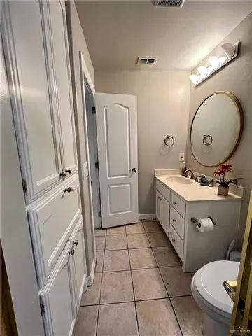 a bathroom with a sink mirror vanity and toilet