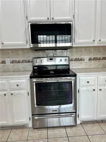 a stove top oven sitting inside of a kitchen