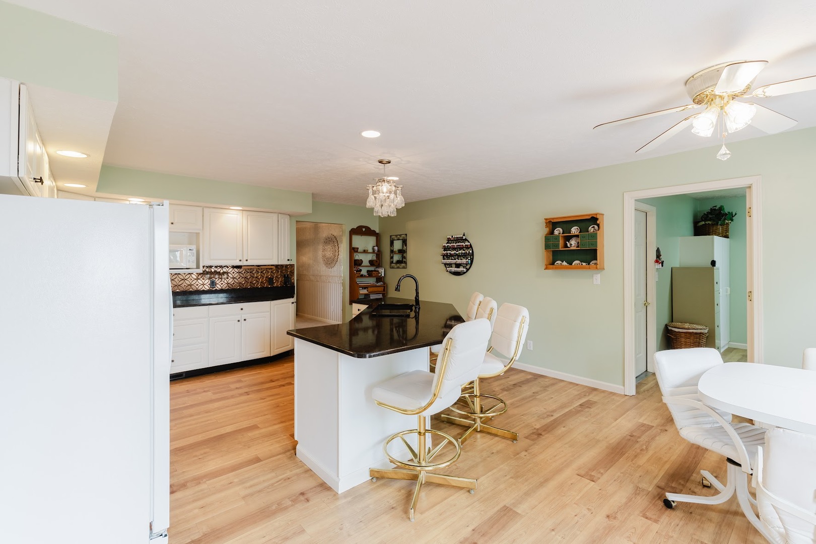 15136 Eastland Road Marion, IL 62959 - Photo 13 of 49 a kitchen with stainless steel appliances kitchen island granite countertop a refrigerator a stove a microwave oven with white cabinets and wooden floor