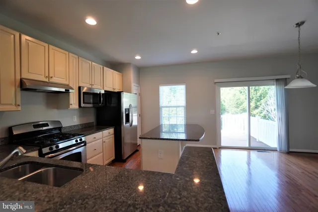 a kitchen with stainless steel appliances a refrigerator a stove a sink a washer dryer and a cabinets