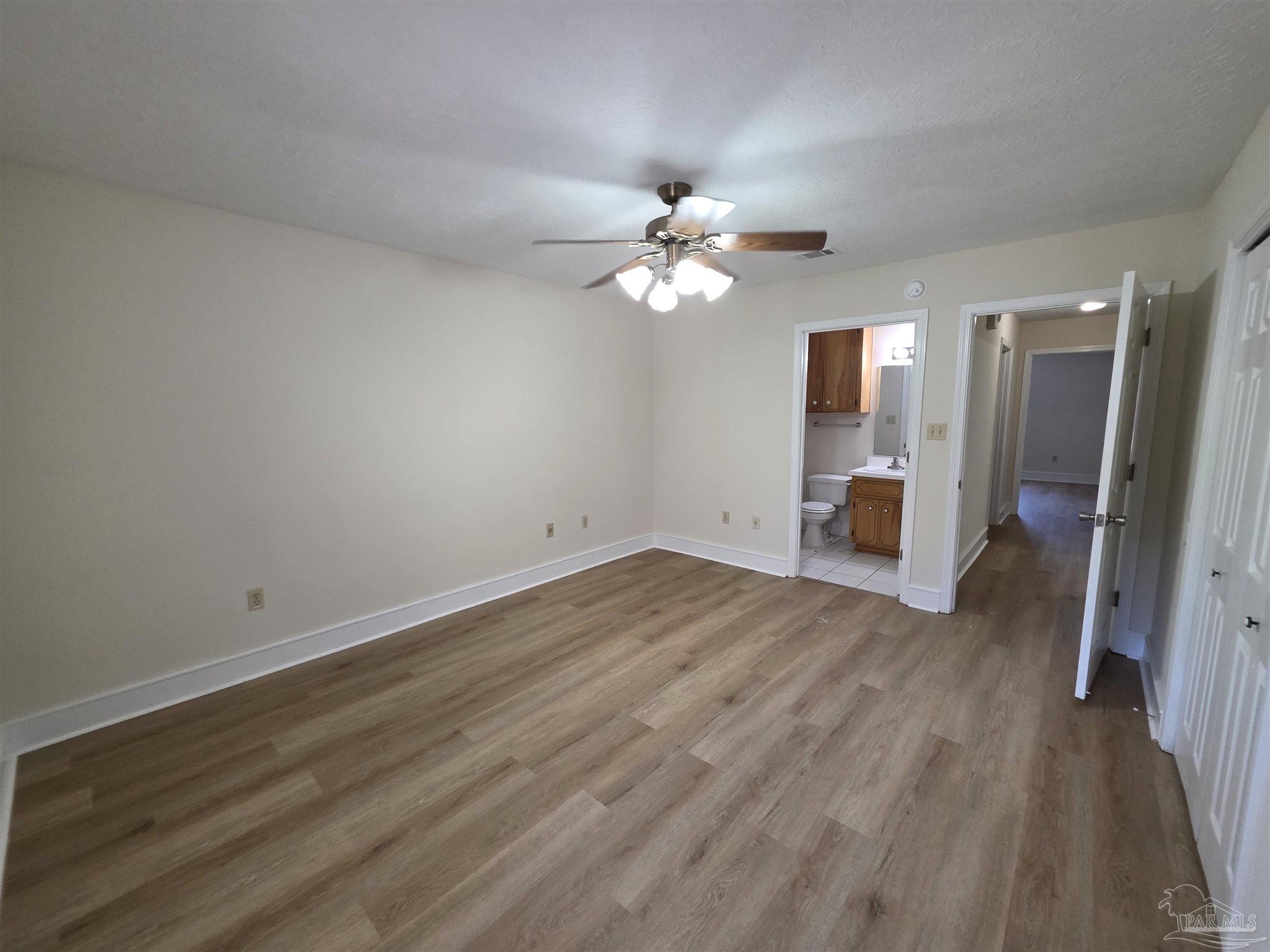 916 Rentz Avenue, Unit A Pensacola, FL 32507 - Photo 11 of 22 an empty room with wooden floor and ceiling fan