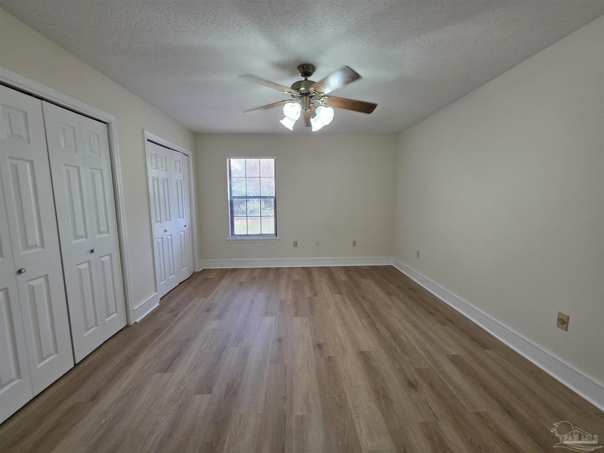 916 Rentz Avenue, Unit A Pensacola, FL 32507 - Photo 8 of 22 wooden floor in an empty room with a window