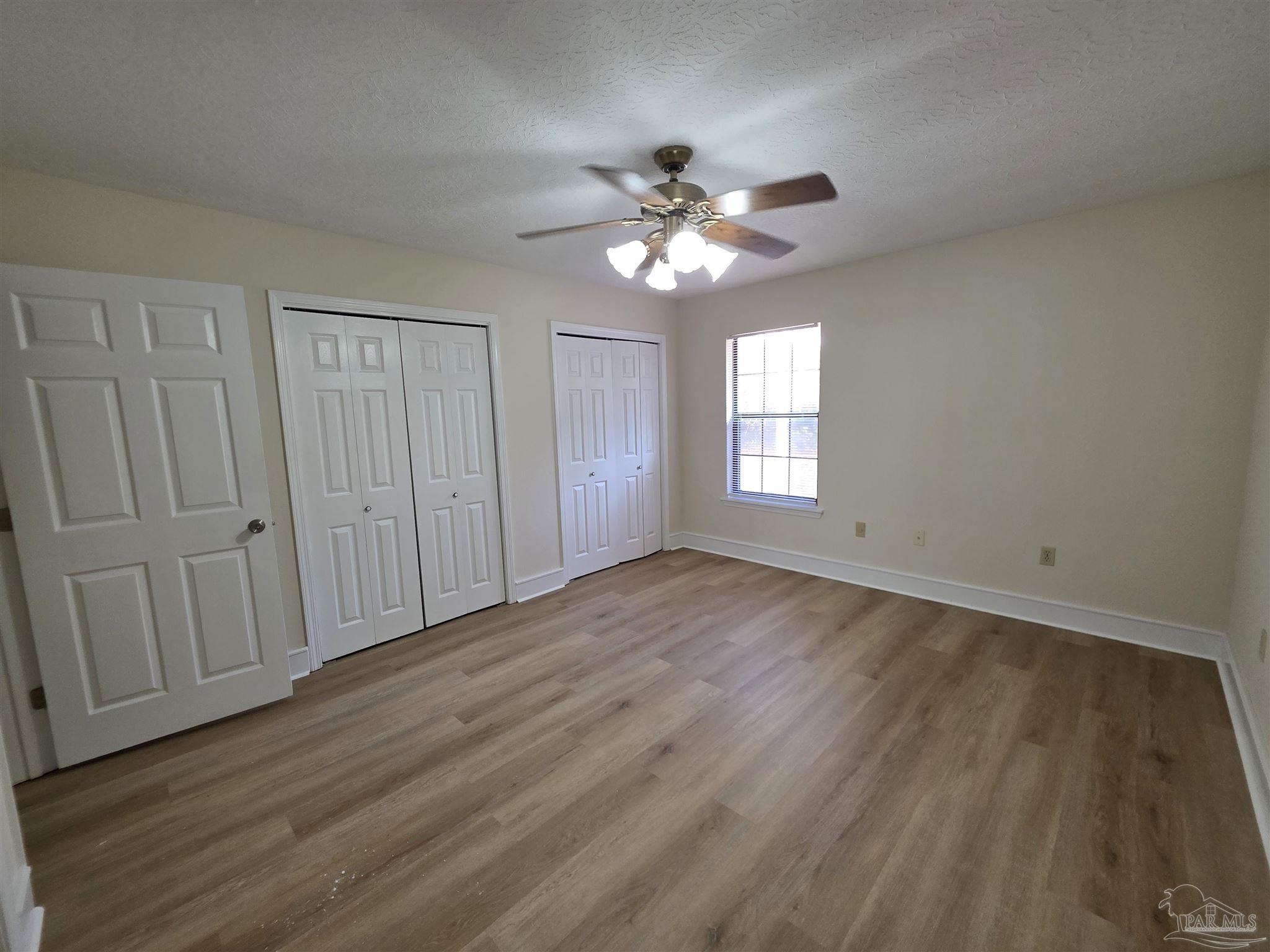 916 Rentz Avenue, Unit A Pensacola, FL 32507 - Photo 9 of 22 a view of empty room with wooden floor and fan