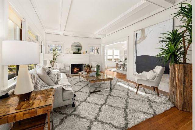 a living room with furniture a table and a potted plant